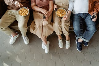 People sitting on couch eating popcorn