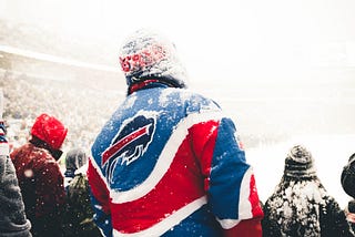 Snowclad back shot of a fan at an NFL football game wearing a Buffalo Bills jacket