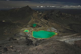 Three turquoise lakes sitting in the middle of rocky terrain.