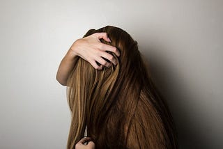 A girl with long hair, her hair is flipped over with her head down!