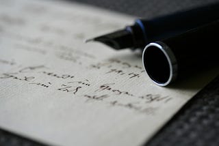 A fountain pen lying on handwritten paper
