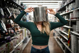A woman with a pot on her head, trying to hide from a situation