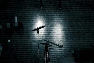 A dark stage with a microphone.