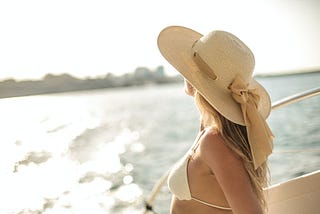 A young lady rocking a hat while enjoying stunning ocean views