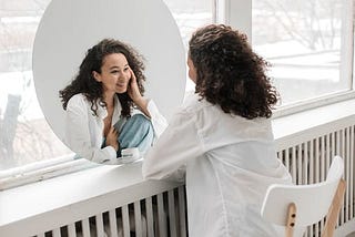 Woman smiling at herself in the mirror