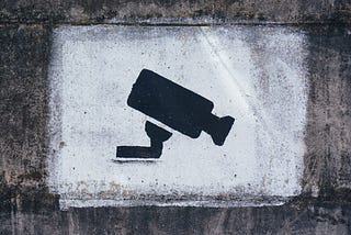 A stencil grafitti of a security camera.