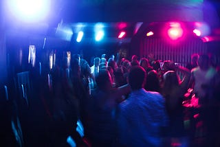 People dancing to electronic music in a nightclub.