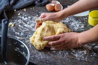 Picture of a person’s hands kneading a ball of dough.