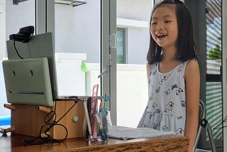 Chinese girl in front of a computer having an online class.