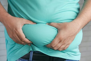 A person squishing their stomach.
