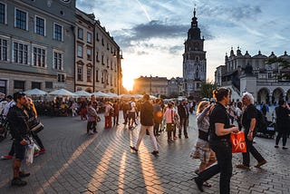 Photo of people walking around main market square in Cracow, Poland.