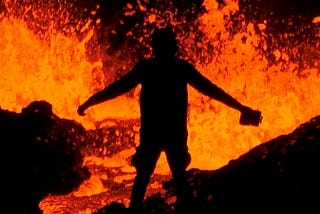 This image depicts a shadowy sillouhette holding a kerosene looking can. There is boiling lava all around them.