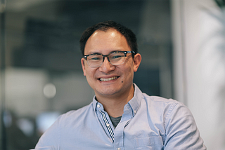 A portrait of Mike Wu, Deputy General Counsel at Carta. He’s smiling.