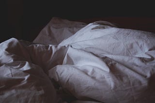 white bedding in a dark room