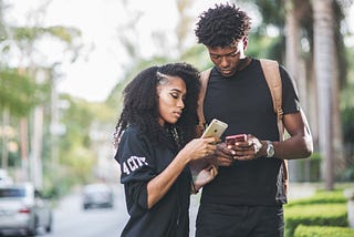 A black man and woman checking out each other's dating profile on FaithMatch