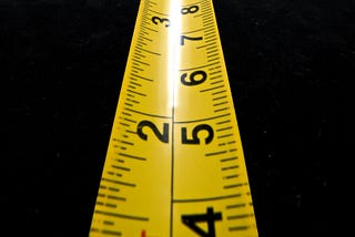 A yellow ruler pointed towards the reader marked both in centimeters and inches.