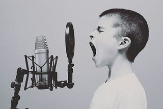 Young boy screaming into a microphone…