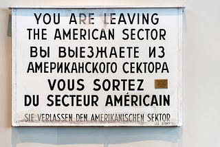 A sign with ‘you are leaving the American sector’ written in multiple languages.