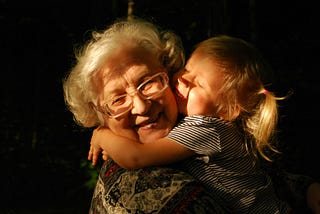 Grandchild hugging her grandmother with love