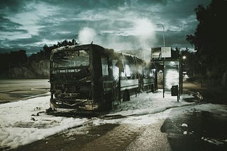 Burnt-out bus standing in front of a bus stop