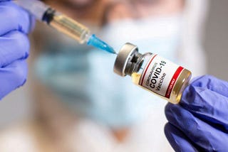 FILE PHOTO: A woman holds a small bottle labeled with a “Coronavirus COVID-19 Vaccine
