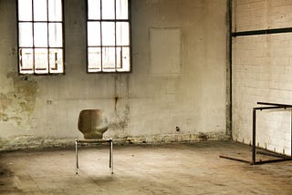 a single chair in a rundown room.