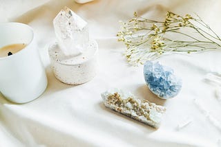 clear and blue crystals on a white background with a candle