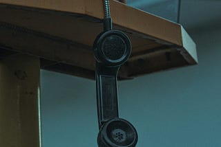 This is an image of a telephone hanging by wire, showcasing the call that I missed. — alt text for medium boost.