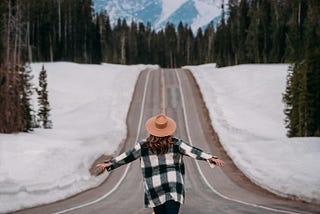 A person walking on the road with snow around them