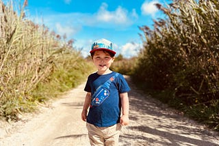 Small boy smiling outside on a farm in the sunshine