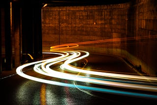 blurred lights of vehicles speeding along a street