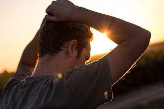 A troubled man with his hands over his head