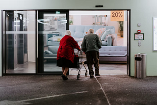2 elderlys walking inside the hospital.