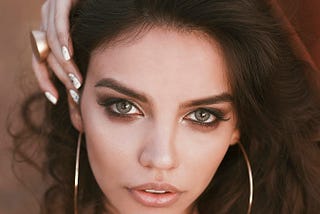 The face of a beautiful young brunette woman with green eyes.