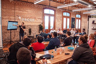 A man explaining things to an audience in a room via a slide deck