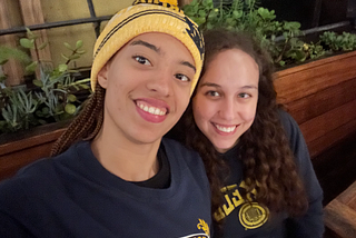 Zoe takes a selfie with a friend with Cal swag on.