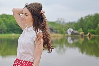 Woman holding long hair. How I Finally Got My Hair To Grow Insanely Long While Maintaining Its Health