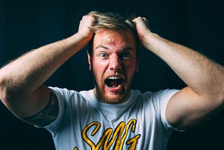 Young man screaming and pulling at his hair humorously