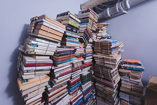 Leaning towers of books held together by rubber bands