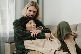 photo of a man with blond hair hugging an Asian woman
