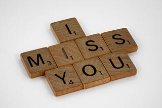 “I miss you” spelled out in Scrabble tiles