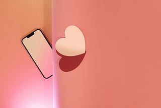 A phone and two paper hearts.