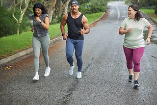 Three runners jogging down the road in conversation