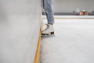 A skater stands next to the wall.