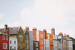 line of old, colorful, brick houses with a cloudy sky