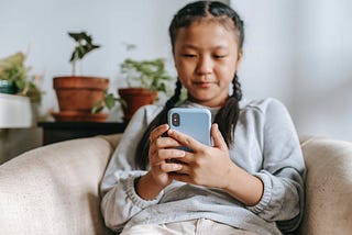 picture of a girl holding a phone while reading it
