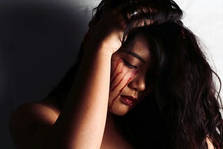 Beautiful young woman weeping bloody tears
