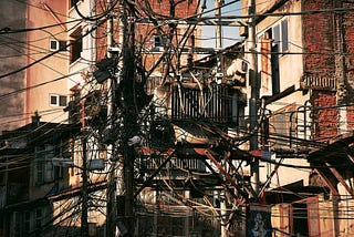 Snapshot of hundreds of wires coming from all directions to be anchored to a power pole.