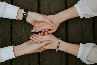 Two women’s hands holding onto each other