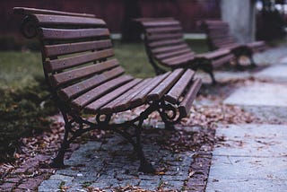 Empty park benches on concrete pavement